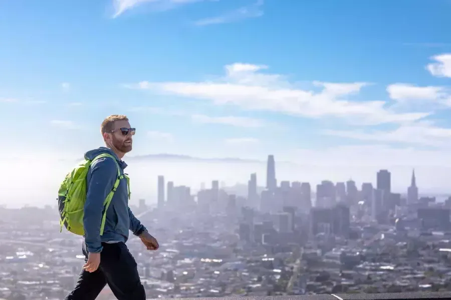 Un visitante camina hasta la cima de Twin Peaks con su mochila.