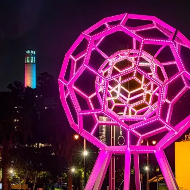 Buckyball risplende all'esterno dell'Exploratorium, con la Coit Tower sullo sfondo